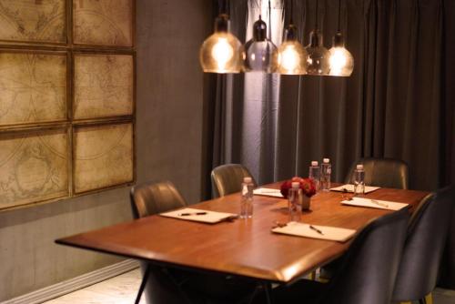 a dining room with a wooden table and chairs at The Drama in Shanghai