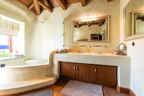 bagno con lavandino, vasca e specchio di Mystiko Art House by Eutopia 