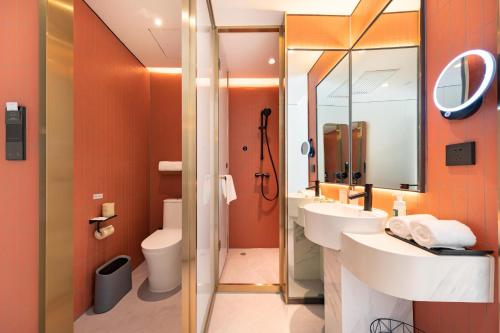 Atour Light Hotel Beijing Tiantongyuan Lishuiqiao Station في بكين: حمام مع مغسلتين ودش