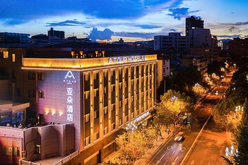 a building with a sign on it in a city at Atour Hotel Kunming Cuihu in Kunming
