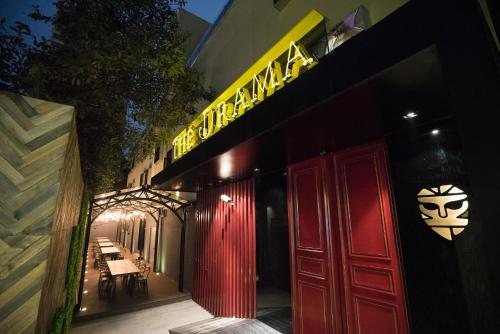 a restaurant with a red door and a neon sign at The Drama in Shanghai