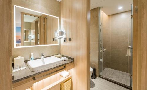 Atour Hotel Wuxi Sanyang Plaza في ووشي: حمام مع حوض ودش
