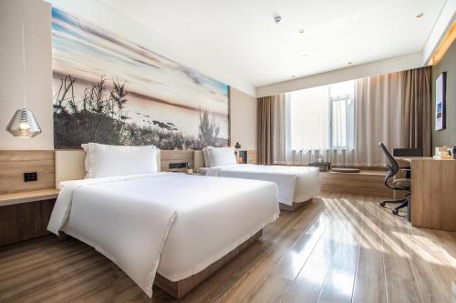 a hotel room with two beds and a desk at Atour Hotel Yantai South Station Yingchun Street in Yantai