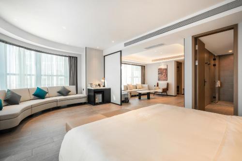 a bedroom with a large bed and a living room at Atour Hotel Chengdu East Station Greenland 468 Center in Chengdu