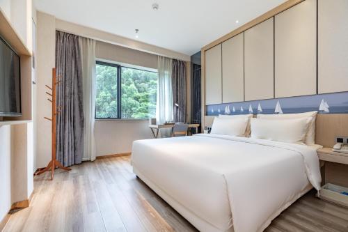 a large white bed in a hotel room at Atour Hotel Xiamen Xiagu Cruise Center in Xiamen