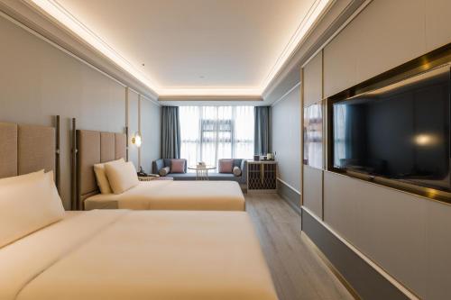 um quarto de hotel com duas camas e uma televisão de ecrã plano em Atour Hotel Chengdu Kuanzhai Alley em Chengdu