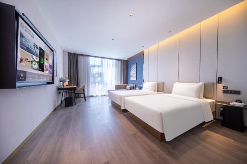 a hotel room with two beds and a flat screen tv at Atour Hotel Beijing Capital Airport New International Exhibition Center in Beijing