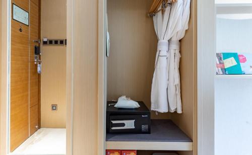 a room with a closet with a door and a room with at Atour Hotel Xiamen Xiagu Cruise Center in Xiamen