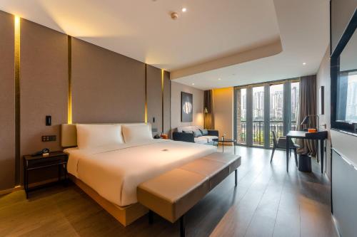 a hotel room with a large bed and a desk at Atour Hotel Chongqing Tiandi NetEase Cloud Music in Chongqing