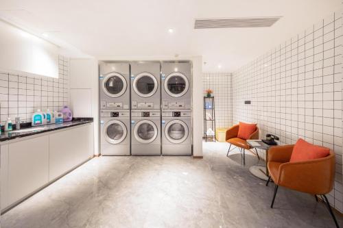 a laundry room with four washing machines in it at Atour Hotel Zhuhai Wanchai Port Hengqin International Convention and Exhibition Center in Zhuhai
