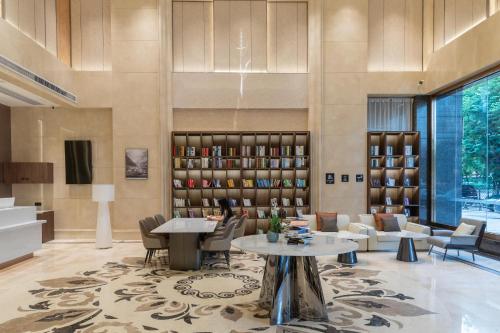 a lobby with a library with tables and chairs at Atour X Hotel Guangzhou Baiyun International Airport Renhe Station in Guangzhou