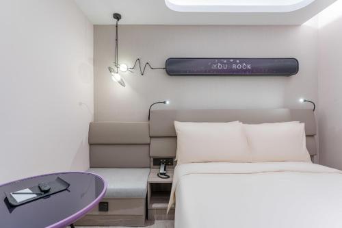 a bedroom with a bed and a purple table at Atour Light Hotel Shanghai Xujiahui Jiaotong University in Shanghai