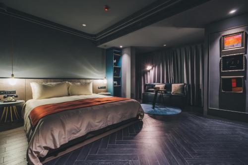 a bedroom with a large bed and a chair at The Drama in Shanghai