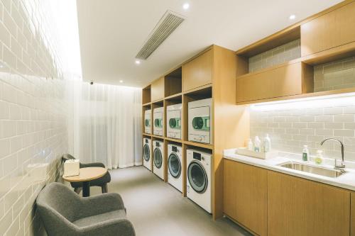 寧波的住宿－宁波三江口外滩书城亚朵酒店，洗衣房配有水槽和洗衣机