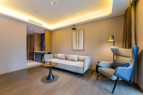 a living room with a couch and two chairs at Atour Hotel Chongqing Tiandi NetEase Cloud Music in Chongqing