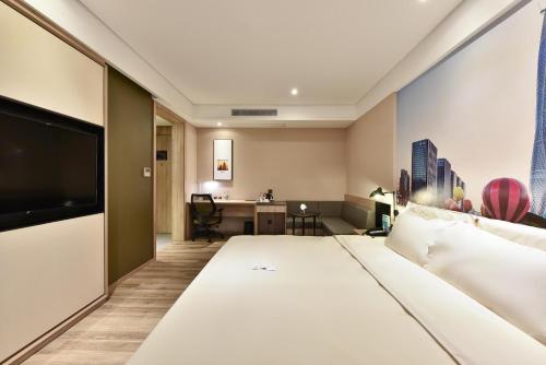a hotel room with a large bed and a desk at Atour Hotel Tianjin Binhai 1st Street in Binhai