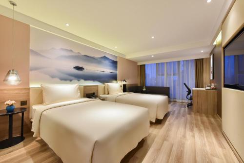 a hotel room with two beds and a television at Atour Hotel Shenyang Railway Station Taiyuan Street in Shenyang