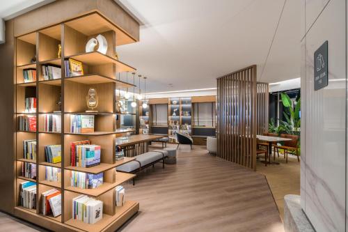 una biblioteca con estanterías de madera llenas de libros en Atour Hotel Shenyang Zhongshan Plaza, en Shenyang