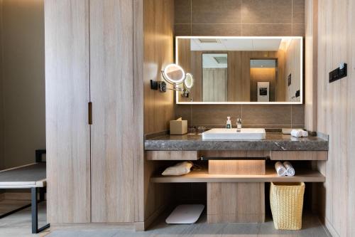 a bathroom with a sink and a mirror at Atour Hotel Yantai South Station Yingchun Street in Yantai