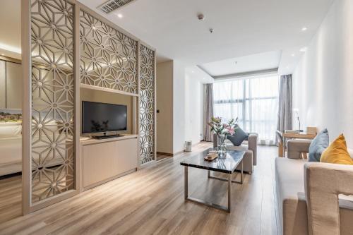a living room with a couch and a tv at Atour Hotel Xiamen Xiagu Cruise Center in Xiamen