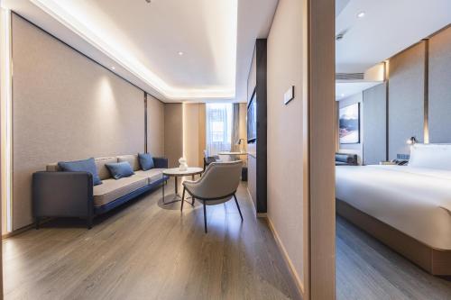 a hotel room with a bed and a couch at Atour Hotel Zhuhai Jinwan Gaolan Port 