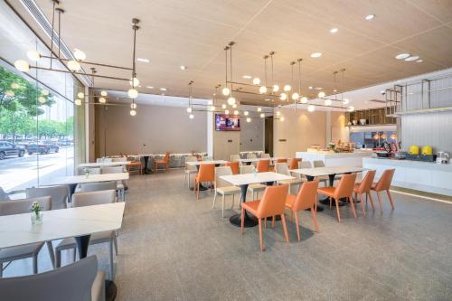 a restaurant with tables and chairs and a counter at Atour X Hotel Shanghai Jinshan Wanda Plaza City Beach in Jinshan