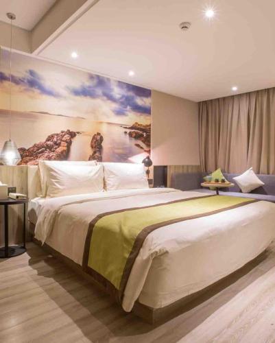 a bedroom with a large bed with a painting on the wall at Atour Hotel Shenzhen Nanshan Coast City in Shenzhen