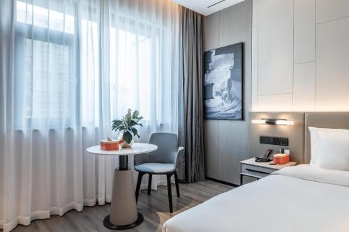a hotel room with a bed and a table and a bedroom at Atour X Hotel Chengdu Shuangnan Wuhou Avenue Station in Chengdu