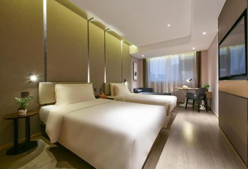 a hotel room with two beds and a table at Atour Hotel Dongguan Nancheng International Trade Center in Dongguan