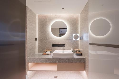 uma casa de banho com um lavatório e um espelho em Atour S Hotel Beijing Shangdi Qinghe High Speed Railway Station em Pequim