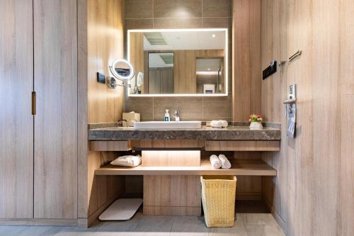 a bathroom with a sink and a mirror at Atour Hotel Yantai South Station Yingchun Street in Yantai
