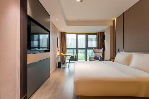 a hotel room with a bed and a television at Atour Hotel Chongqing Tiandi NetEase Cloud Music in Chongqing