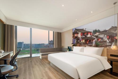 a bedroom with a large white bed and a large window at Atour Hotel Shanghai Minhang Industrial Park in Shanghai