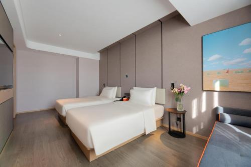 a hotel room with two beds and a couch at Atour Hotel Lijiang Old Town Waterwheel in Lijiang