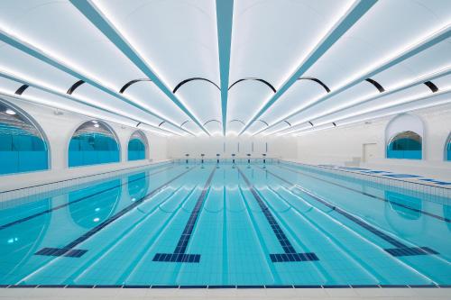 an indoor swimming pool with blue water at A T HOUSE Shanghai City Center Xujiahui - Free Night Snacks from 930pm-11pm in Shanghai