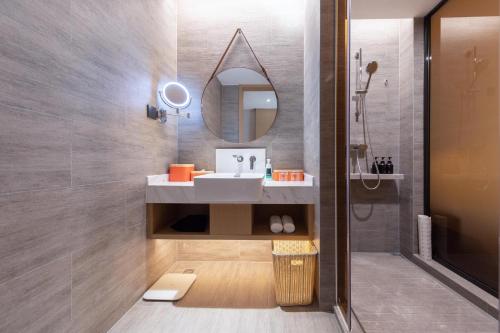 a bathroom with a sink and a mirror at Atour Hotel Shenzhen Nanshan Xili Station in Shenzhen