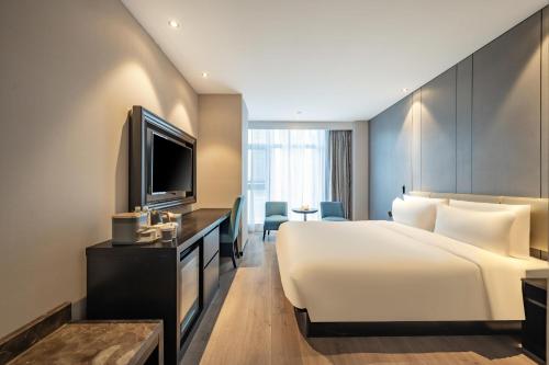 a hotel room with a bed and a television at Atour X Hotel Hangzhou Binjiang Jiangnan Avenue in Hangzhou