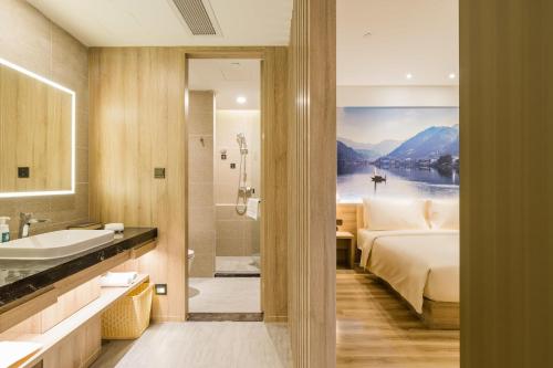 杭州的住宿－杭州西湖文化广场地铁站上塘路亚朵酒店，一间带床、浴缸和水槽的浴室