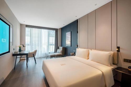 een slaapkamer met een groot wit bed en een bureau bij Atour Hotel Chengdu High Tech West District Government Affairs Center in Chengdu