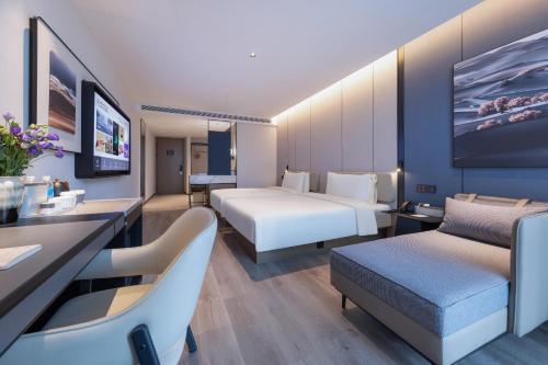 una camera d'albergo con due letti e una scrivania di Atour Hotel Nanjing Jinma Road Station a Nanjing