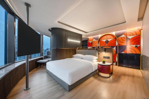 um quarto com uma cama branca e uma grande janela em A T HOUSE Shanghai Xujiahui em Xangai