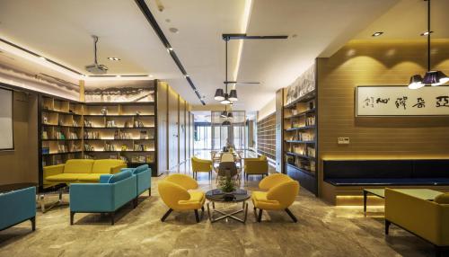 a library with yellow and blue chairs and a table at Atour Hotel Hangzhou Xiaoshan Peoples Square in Hangzhou