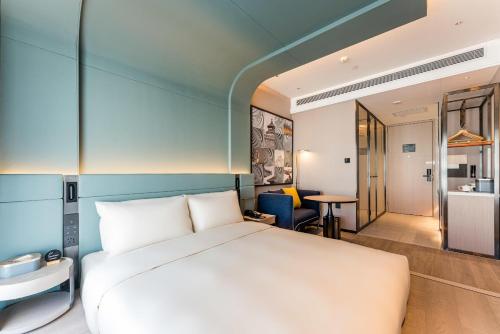 a bedroom with a white bed and a table at Atour S Hotel Beijing Shangdi Qinghe High Speed Railway Station in Beijing