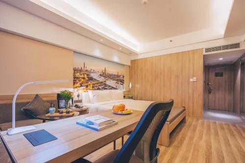 a hotel room with a desk and a bed at Atour Hotel Shanghai Wujiaochang Dabaishu in Shanghai