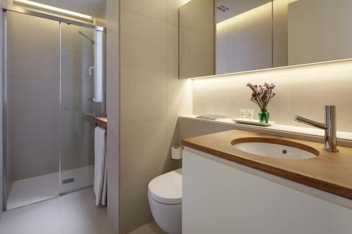 La salle de bains est pourvue de toilettes, d'un lavabo et d'une douche. dans l'établissement Mur by Feelfree Rentals, à Saint-Sébastien