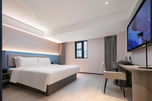 een hotelkamer met een bed en een bureau bij Atour Light Hotel Wuhan Jiangtan Jianghan Road Pedestrian Street in Wuhan