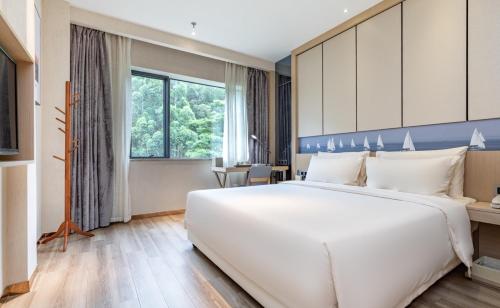 a large white bed in a hotel room at Atour Hotel Xiamen Xiagu Cruise Center in Xiamen