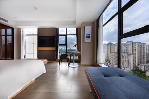 una camera con letto, scrivania e finestre di Atour Hotel Guiyang Guanshan Lake Park a Guiyang