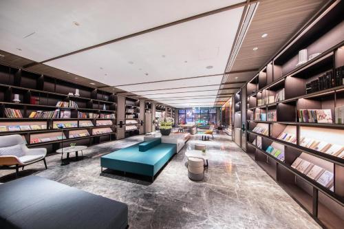 a library with a blue couch and bookshelves at Atour Hotel Taian Taishan Internation Convention and Exhibition Center in Tai'an