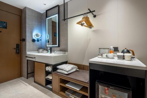 uma casa de banho com um lavatório e um espelho em Atour Hotel Zhoushan Putuo Banshengdong Wharf em Zhoushan